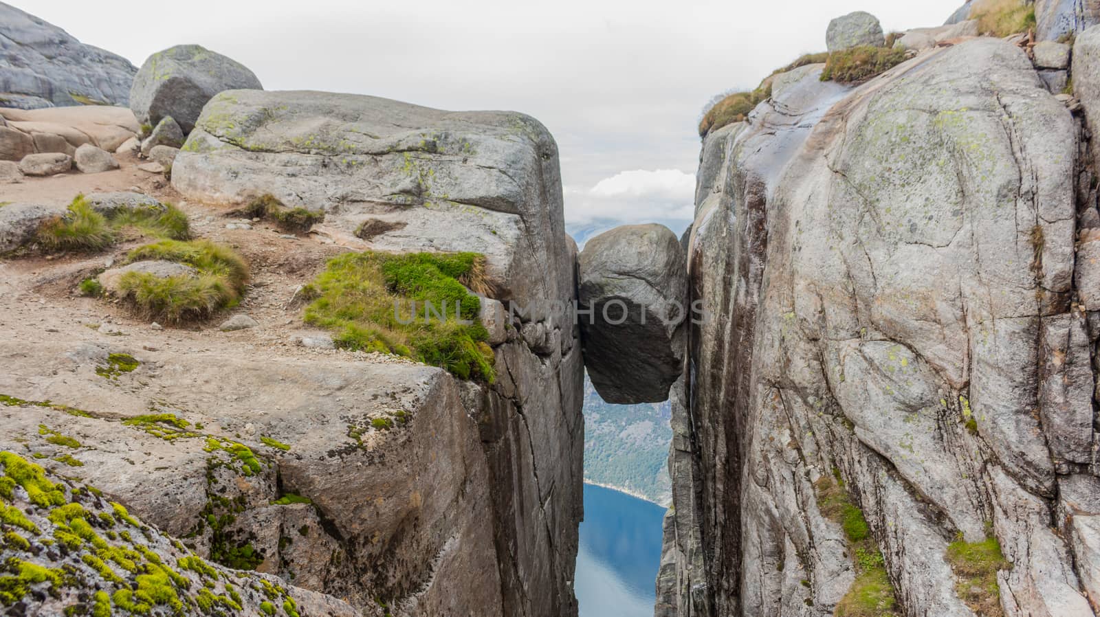 Kjerag Kjeragbolten above the Lysefjord. Norway's most beautiful landscape. by Arkadij