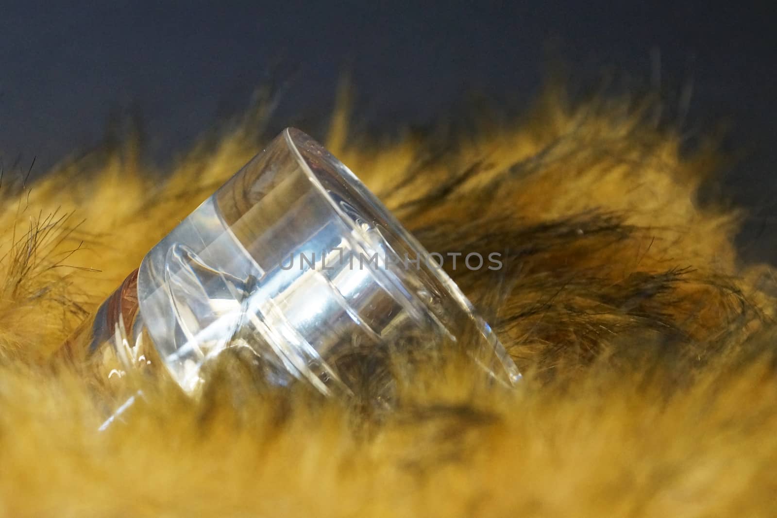 perfume bottle in yellow fur on a black background close-up