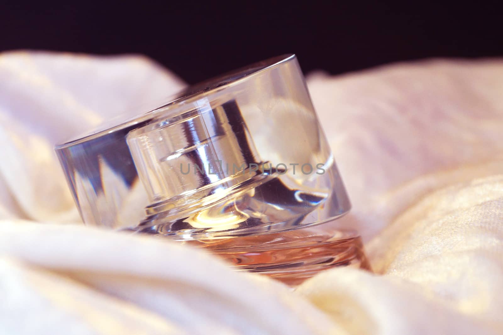 perfume bottle on white shiny cloth close-up