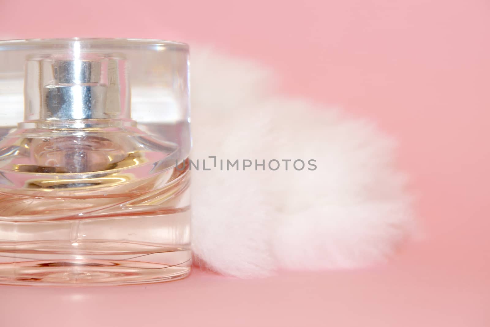 perfume bottle and white fur on a pink background by Annado