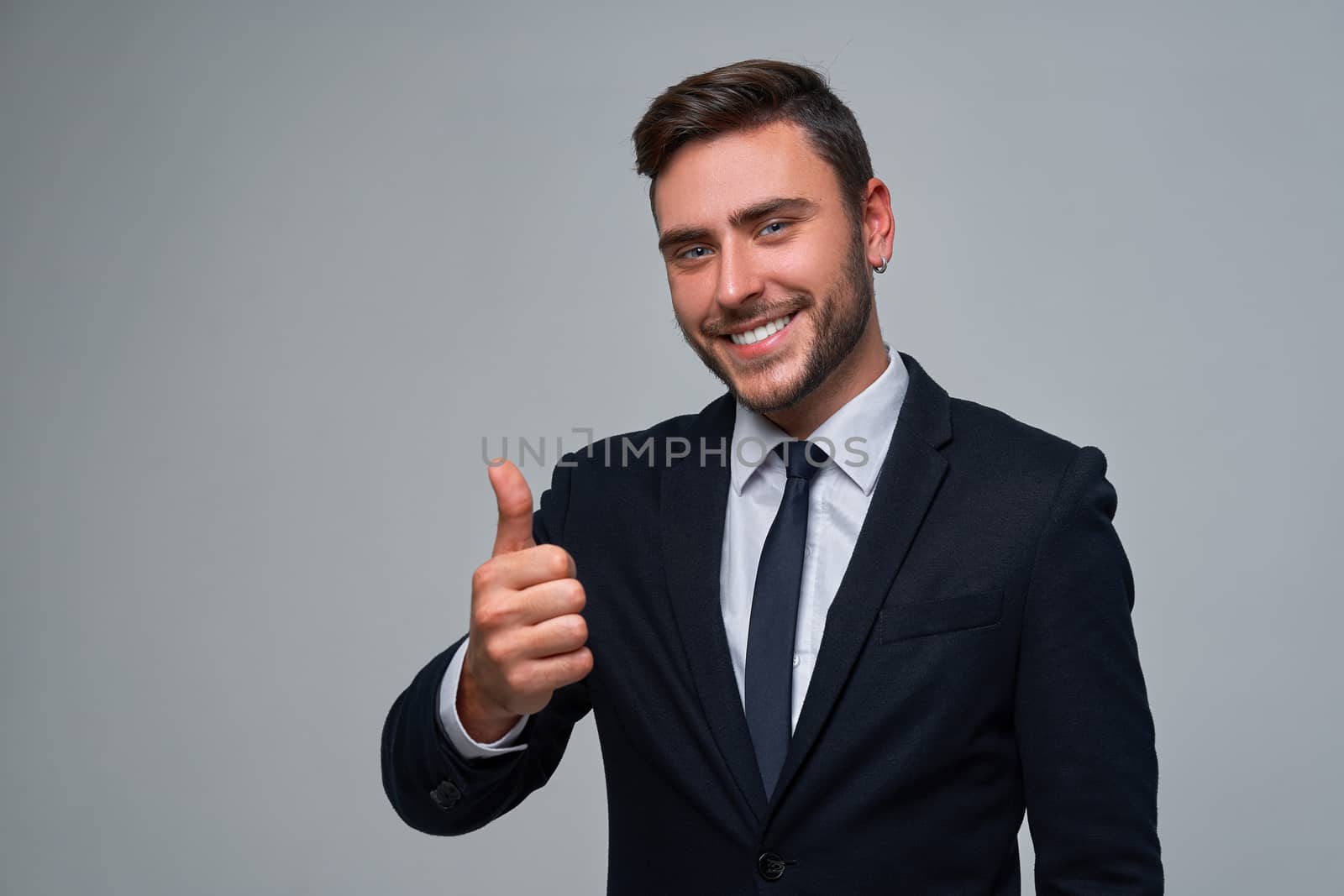 Businessman Business person. Man business suit studio gray background. Modern millenial person Showing thumbs up sign. Portrait of charming successful happy entrepreneur