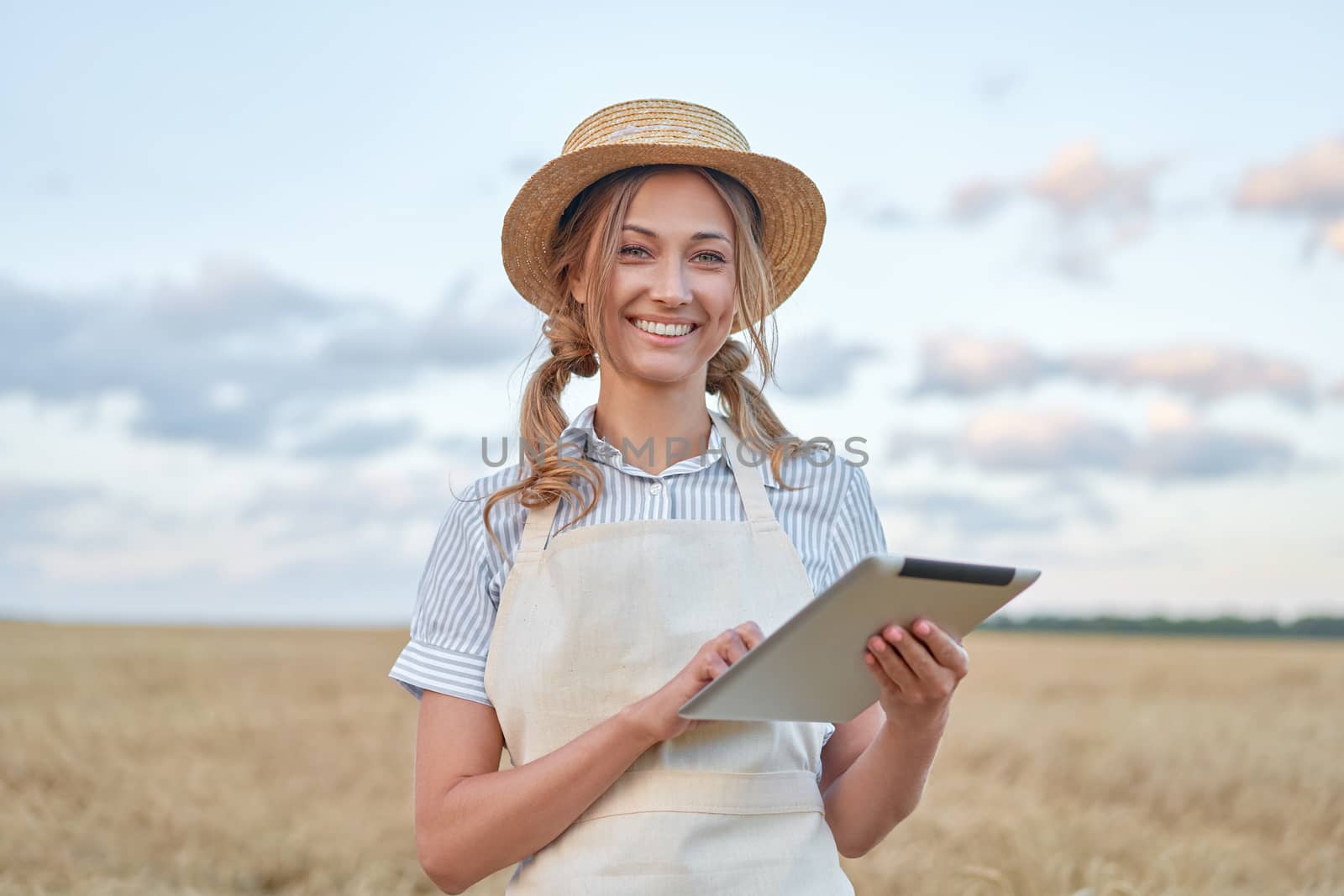 Woman farmer straw hat smart farming standing farmland smiling using digital tablet Female agronomist specialist research monitoring analysis data agribusiness Caucasian worker agricultural field