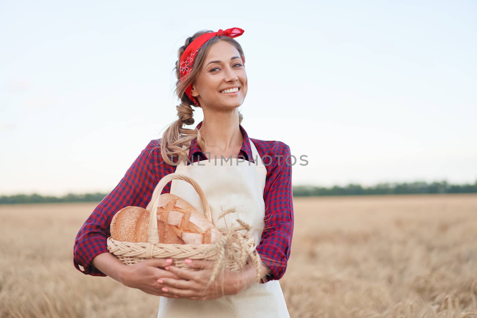 Female farmer standing wheat agricultural field Woman baker holding wicker basket bread eco product Baking small business Caucasian person dressed red checkered shirt apron organic healthy food
