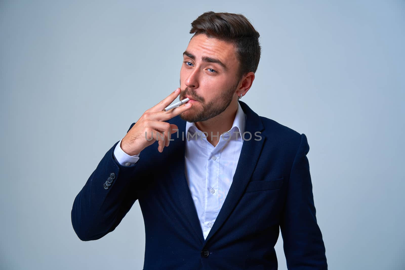 Businessman Business person. Man business suit studio gray background. Modern business person stylish haircut smokes a cigarette Portrait of charming successful young entrepreneur