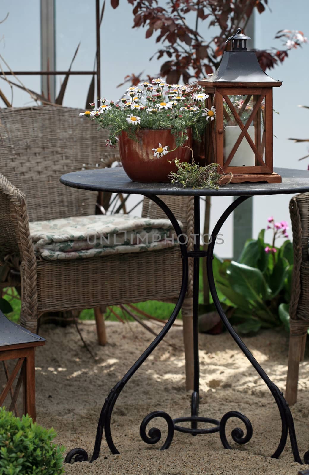 Outdoor table and chair with daisy flower pot and lantern with candle