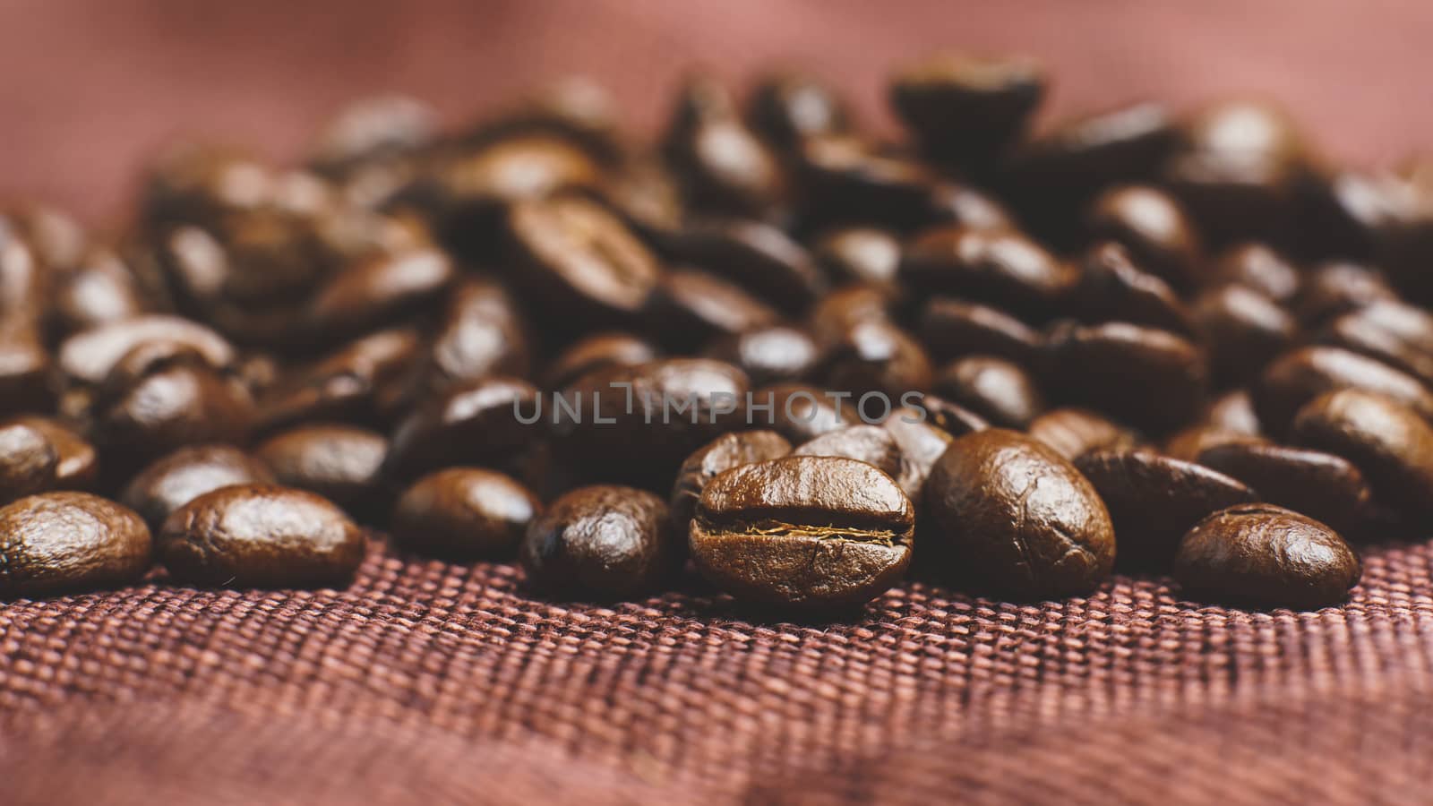 Roasted coffee beans pile on burlap