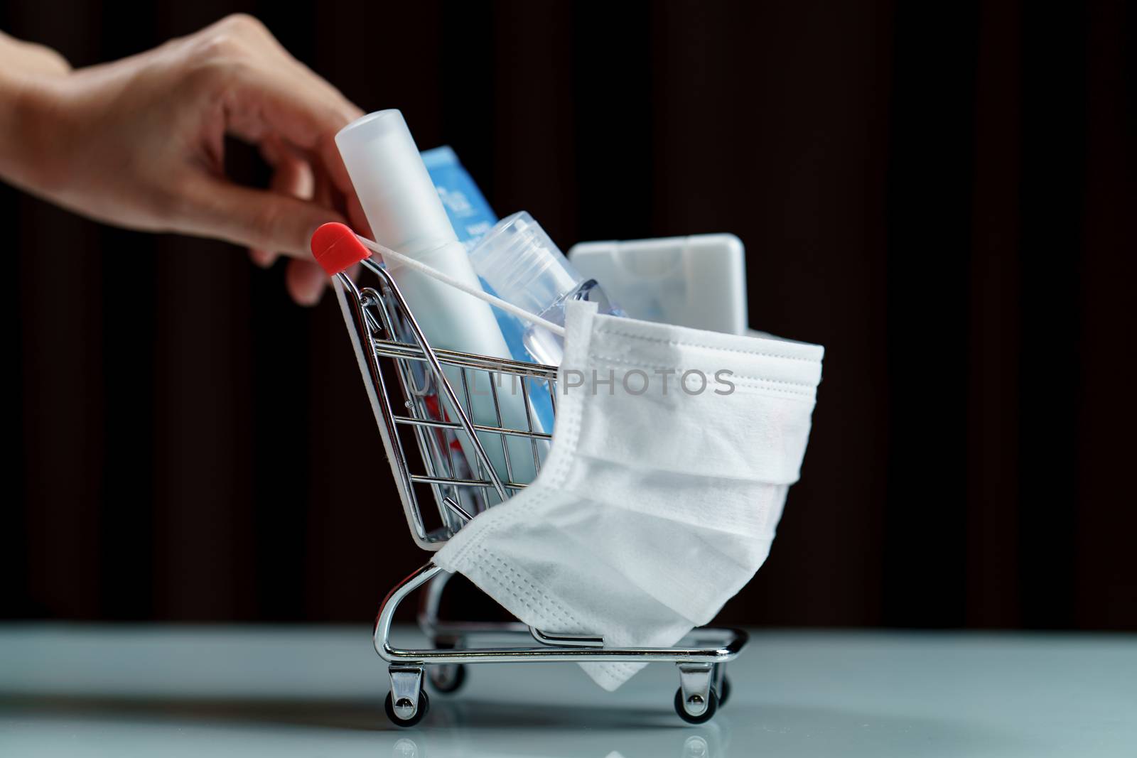 Hands pushing shopping cart and sanitizer products with protecti by sirawit99