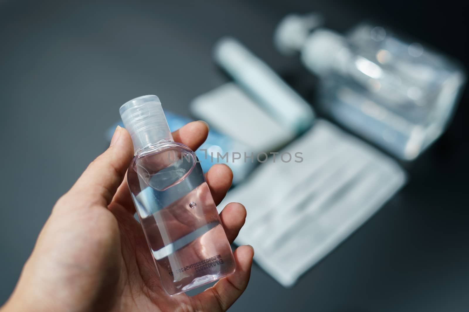 Hand with Bottle alcohol gel and mask on table, must have item d by sirawit99