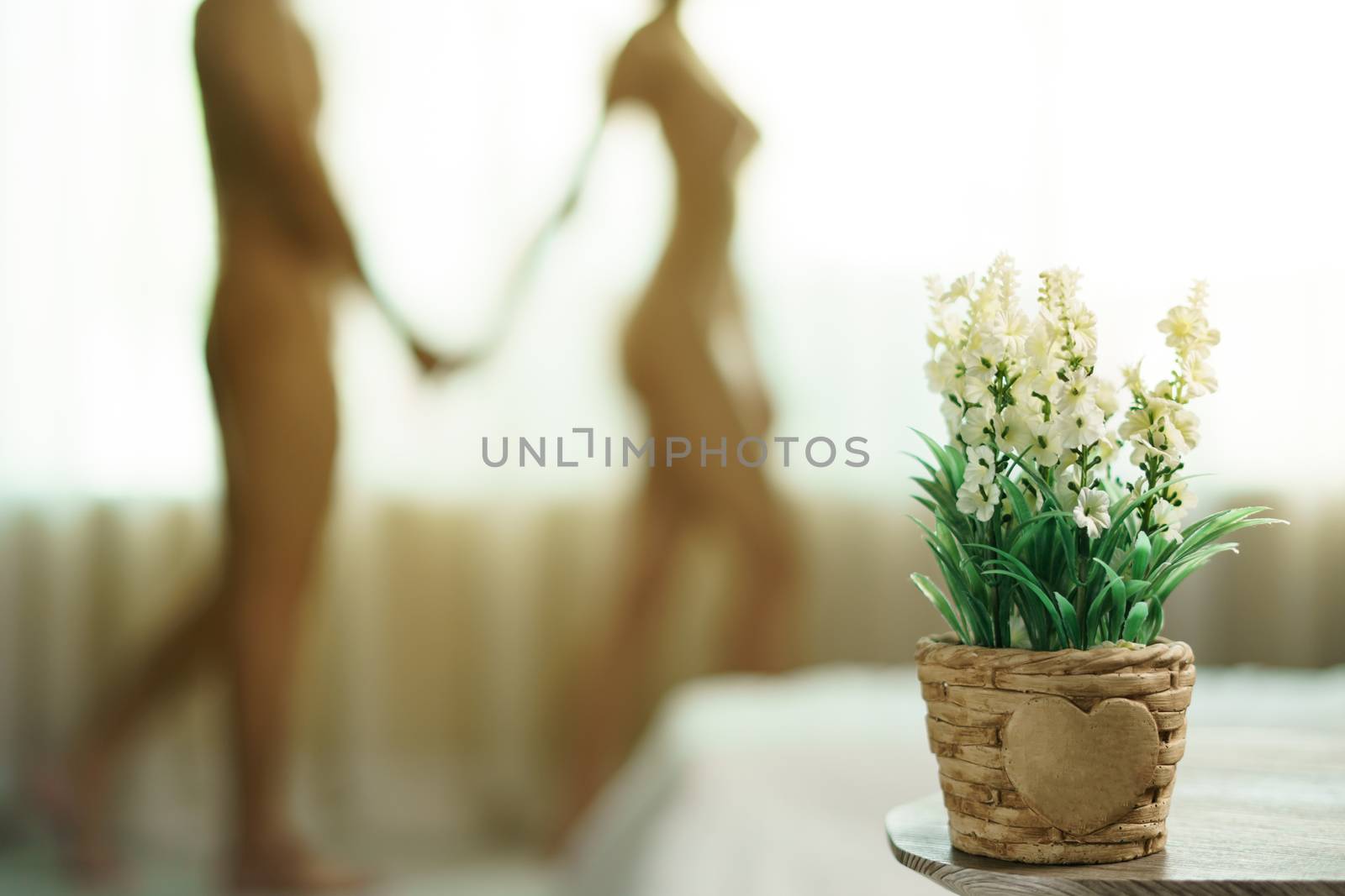 Blurred naked couple standing together at window and holds her h by sirawit99