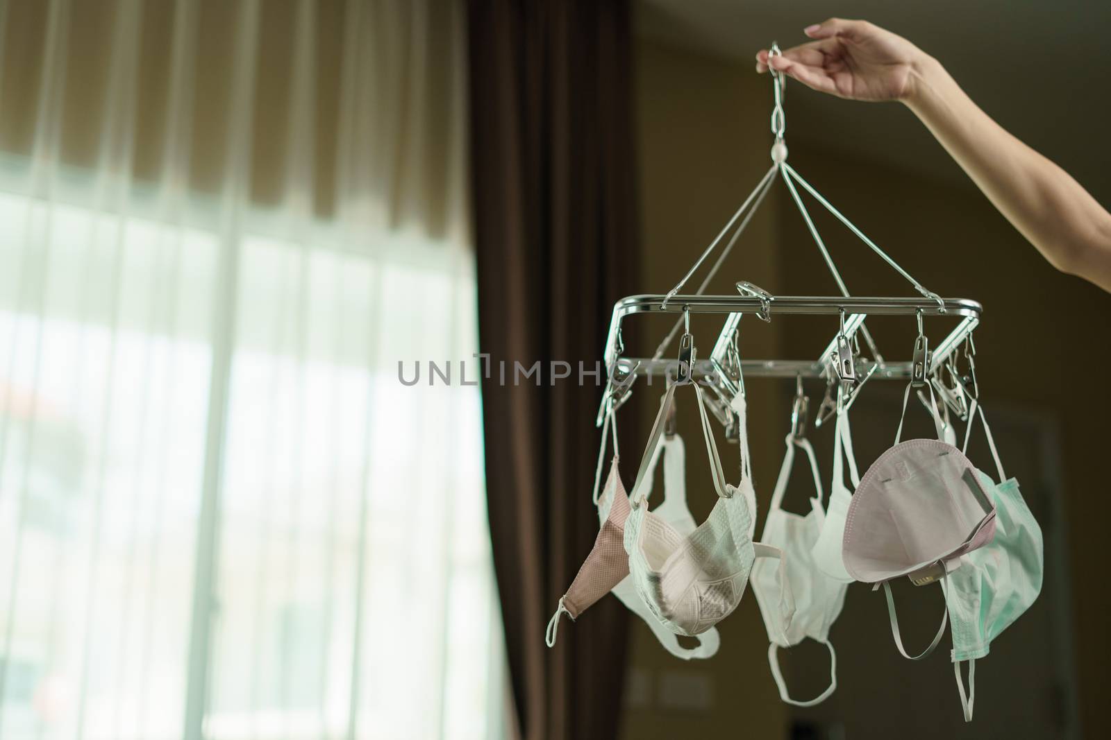 Surgical mask hanging from a drying rack after use and wash. Concept reusing masks.