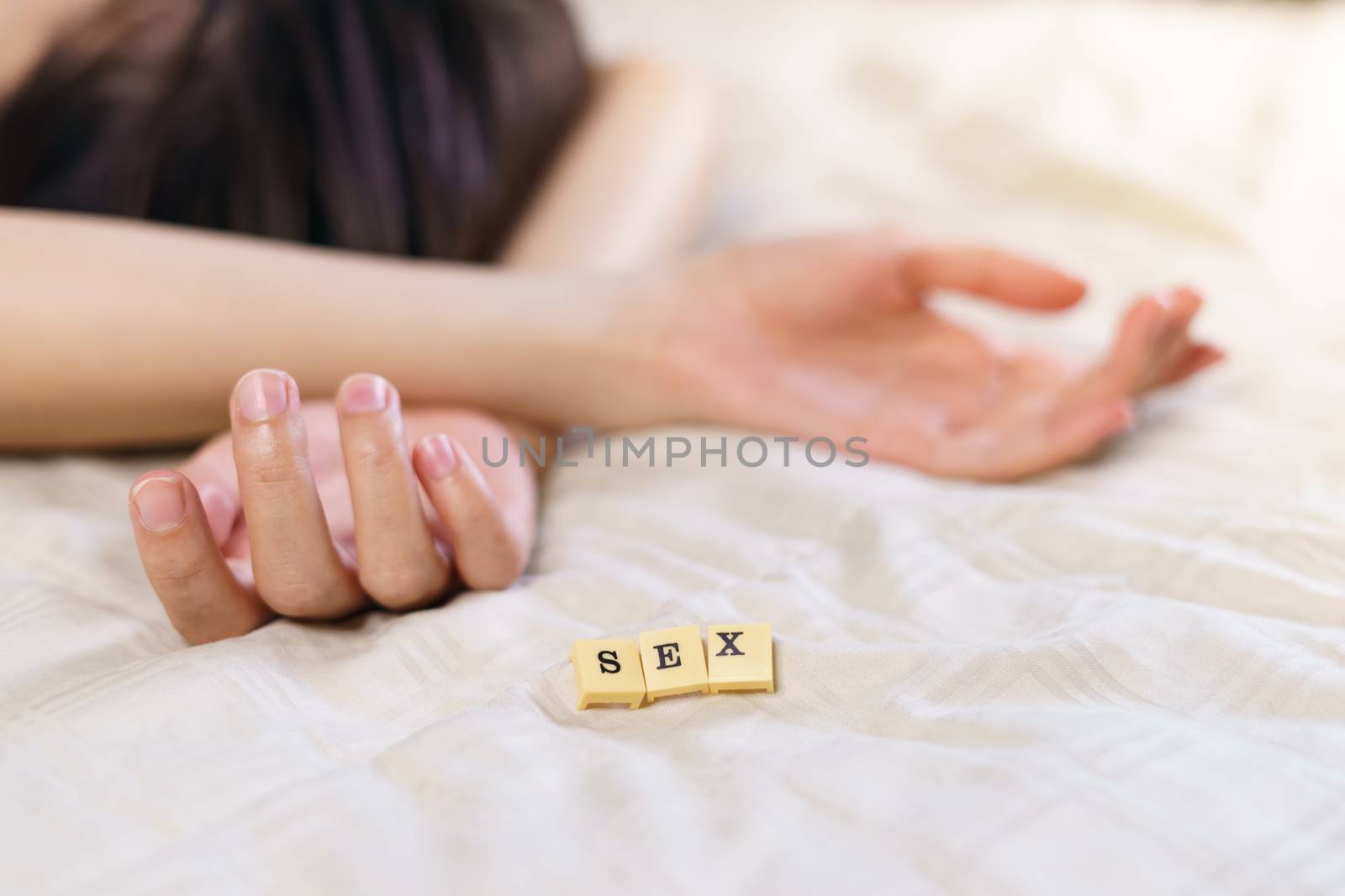 Woman hand sign relax on bed with alphabet showing words sex. by sirawit99