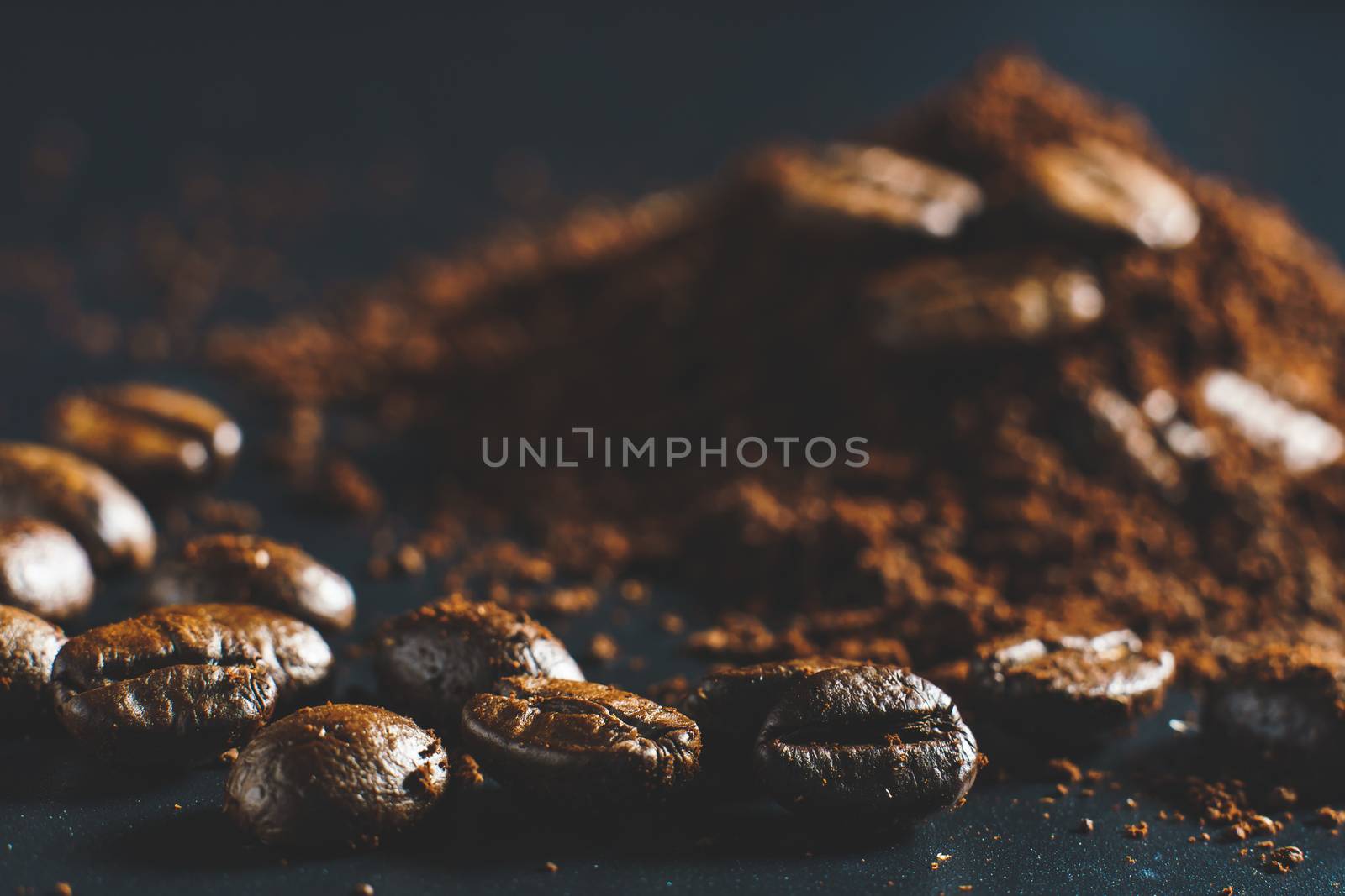 Ground coffee and coffee beans on black background.