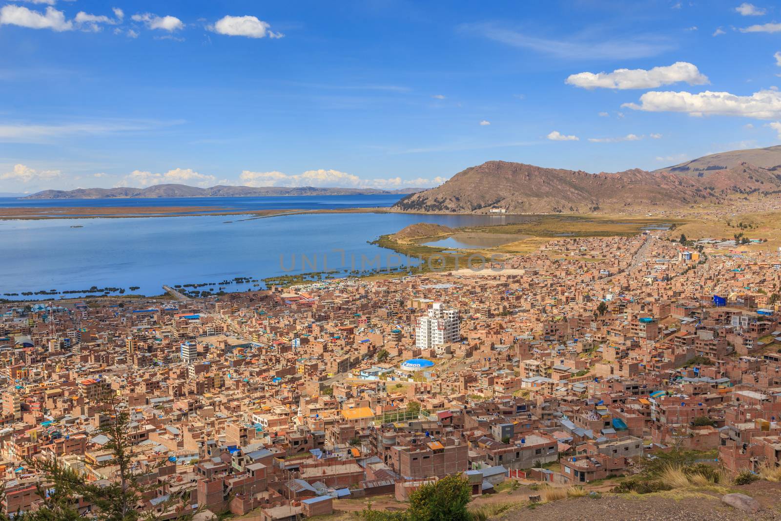 Panorama of peruvian city Puno and lake Titicaca, Peru by ambeon