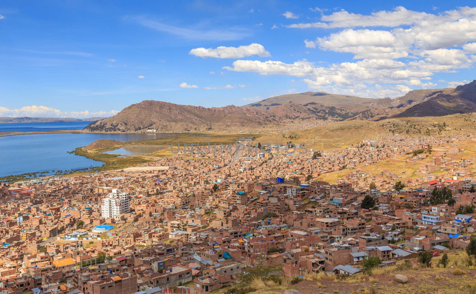 Panorama of peruvian city Puno and lake Titicaca, Peru by ambeon