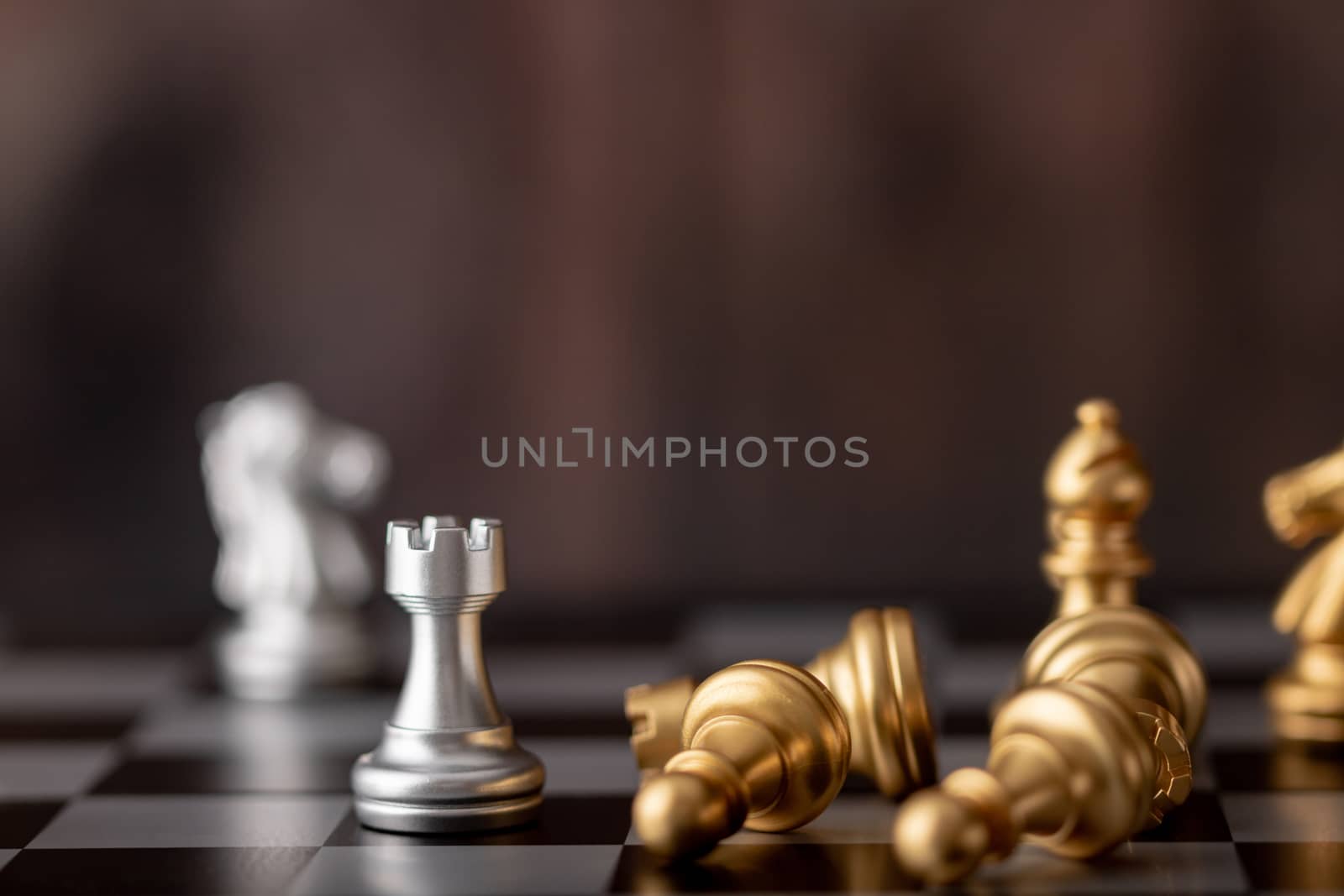 Silver and gold chess on the board and wooden background