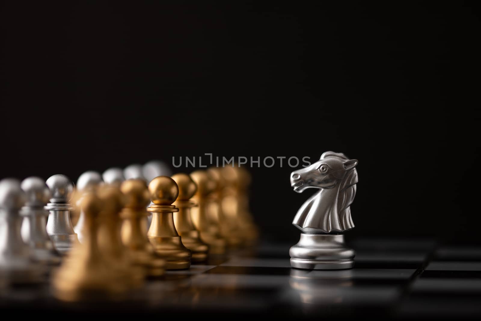 silver hores is the leader of the chess in the game on board with black background.