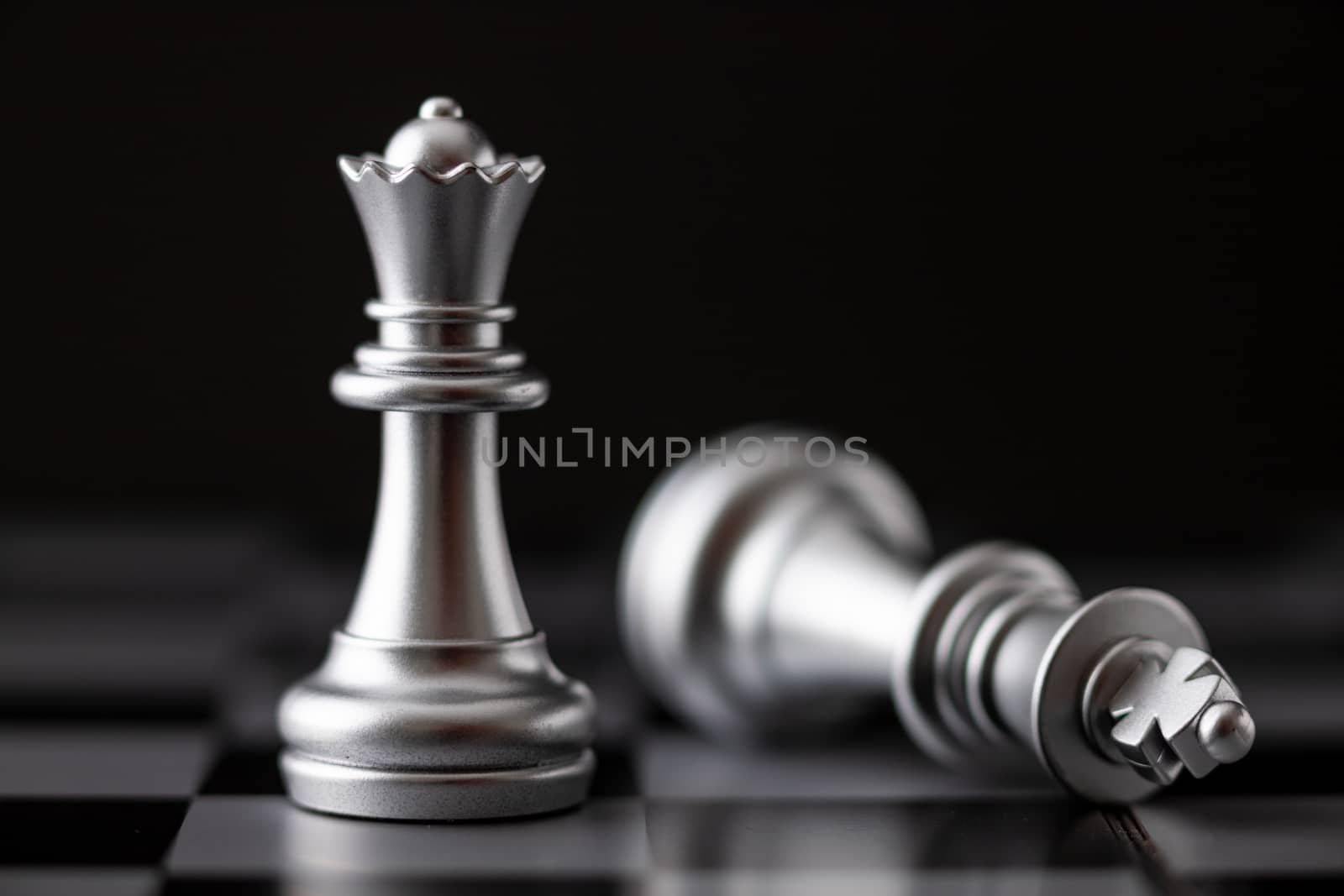 Silver king and queen in game on the chessboard by Nikkikii