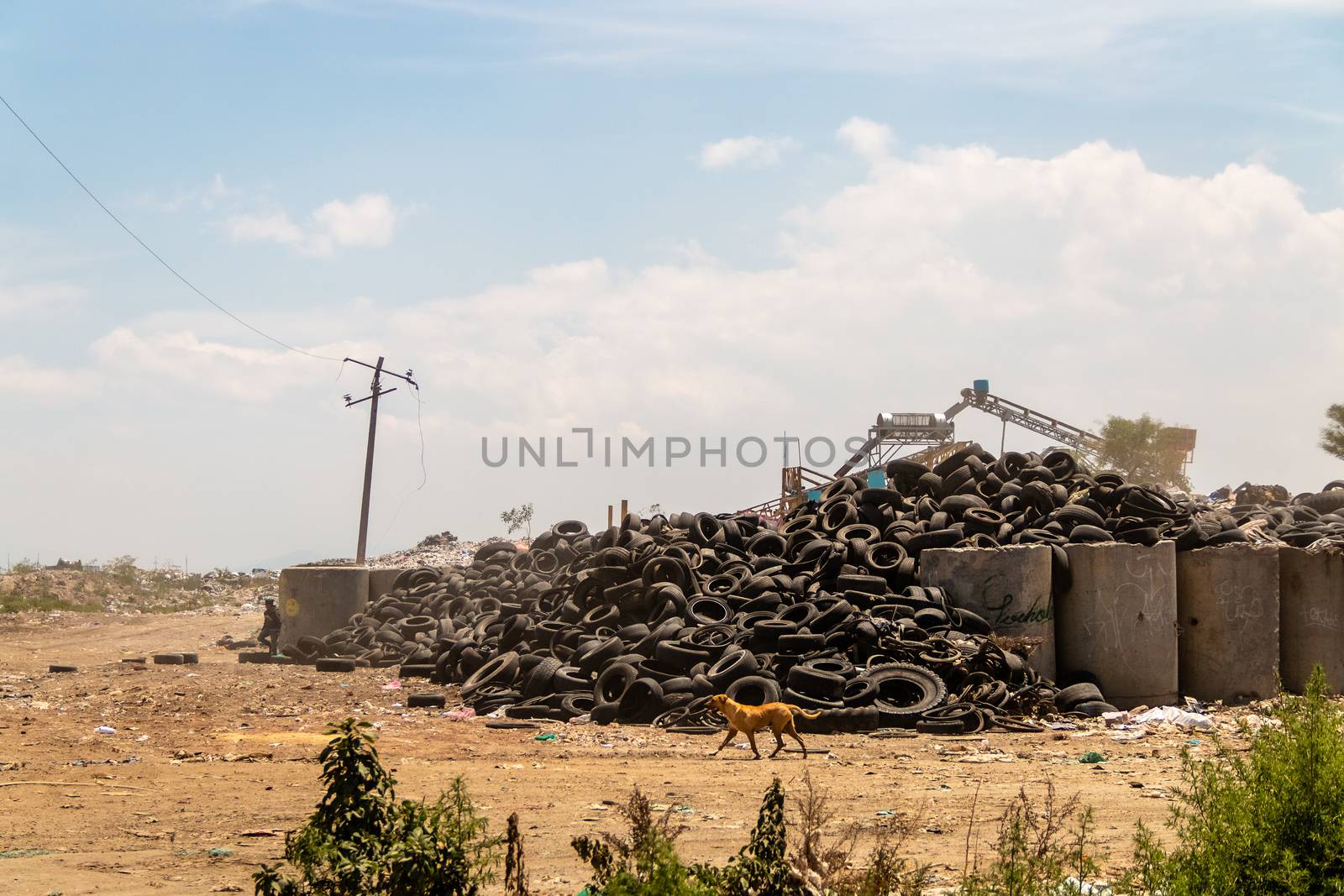 Industrial landfill for the transformation of waste tires and rubber tires. Stack of old tires and wheels for rubber recycling. Tire dump