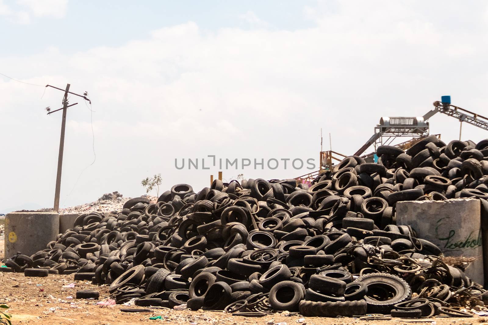 Industrial landfill for the transformation of waste tires and rubber tires. Stack of old tires and wheels for rubber recycling. by leo_de_la_garza