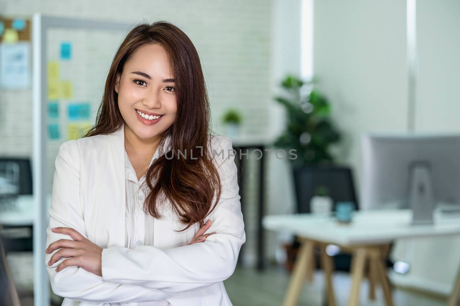 Portrait of Asian Business woman with Arms Crossed and standing at modern workplace, human resource and small business owner, hiring new employee, business person concept