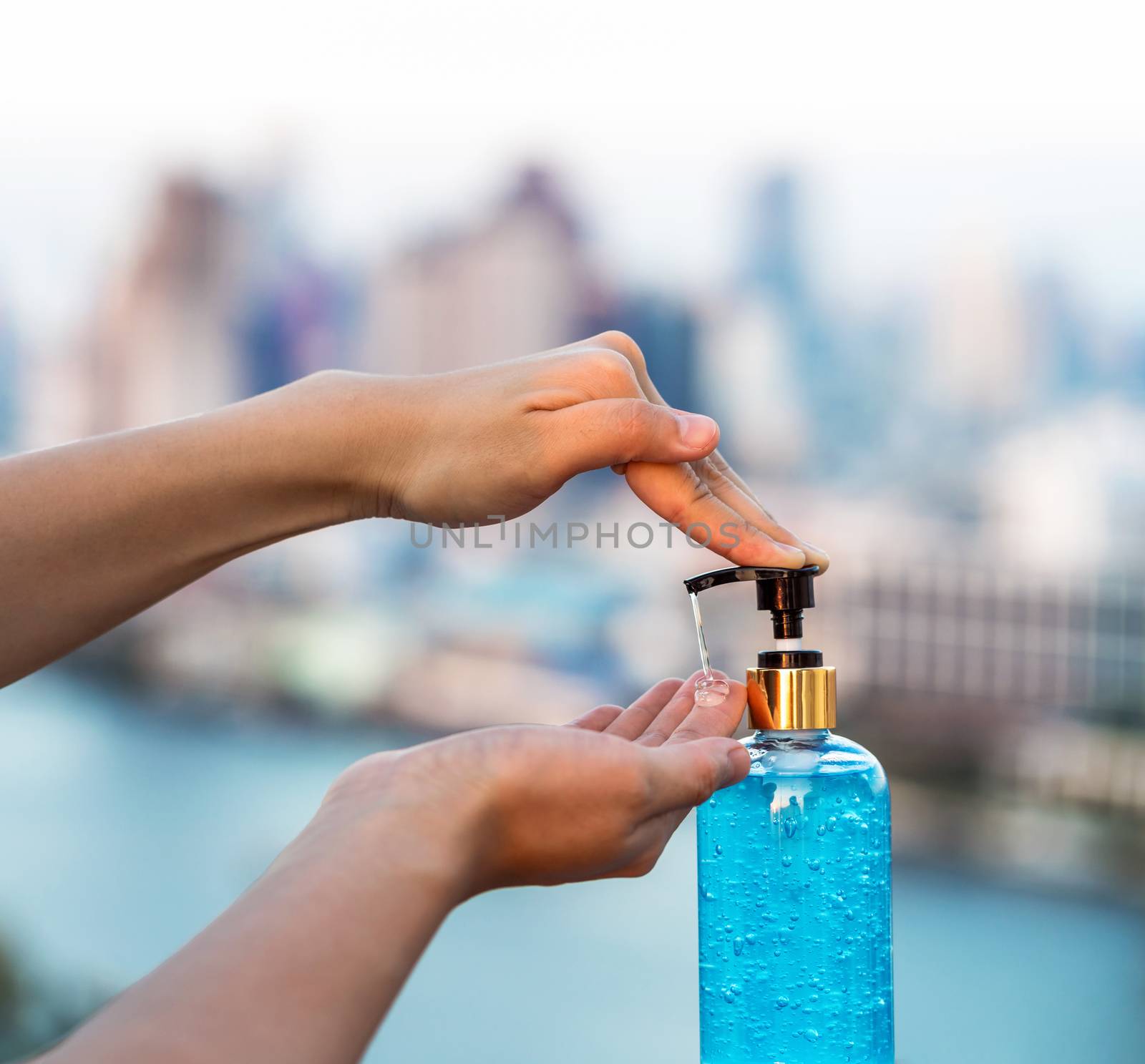 Closeup Asian woman hand using wash hand sanitizer gel pump dispenser before work over blurred of citiyscape while Coronavirus Network Outbreak, health care and cleaning for prevent covid19 concept