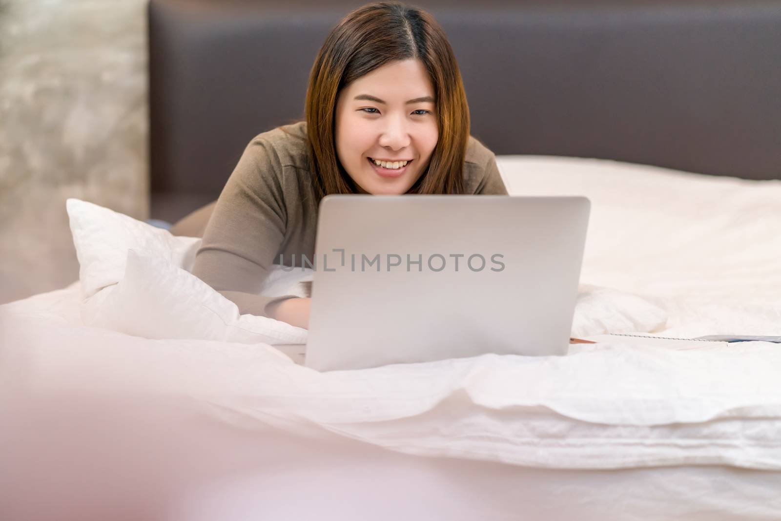 Asian business woman using technology laptop and working from home in indoor bedroom,freelance and entrepreneur,startups and business owner,lifestyle occupation,social distance and self responsibility