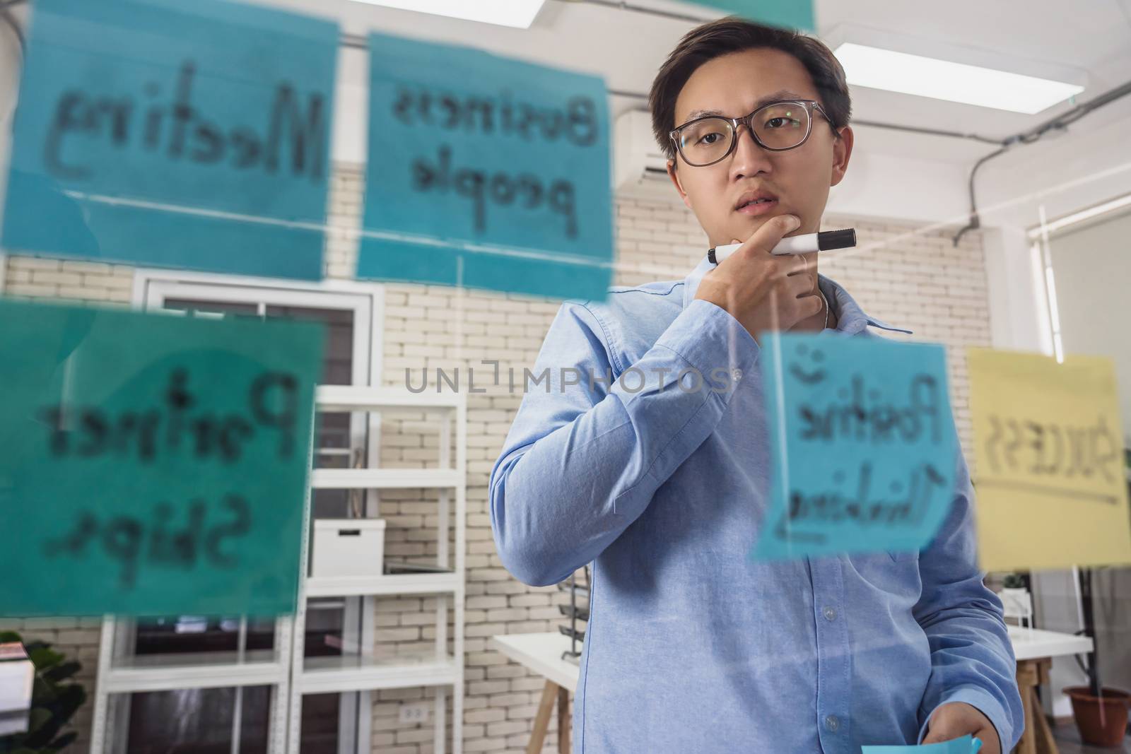 Asian Business man concentrating and thinking before putting the by Tzido