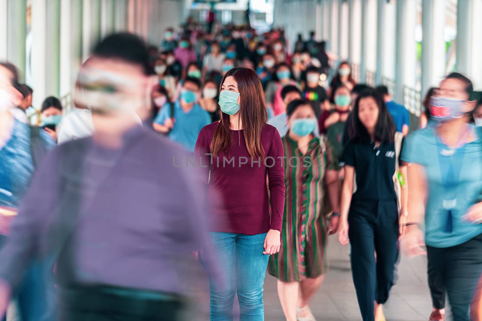 Asian woman walking and standing between Crowd of blurred unreco by Tzido