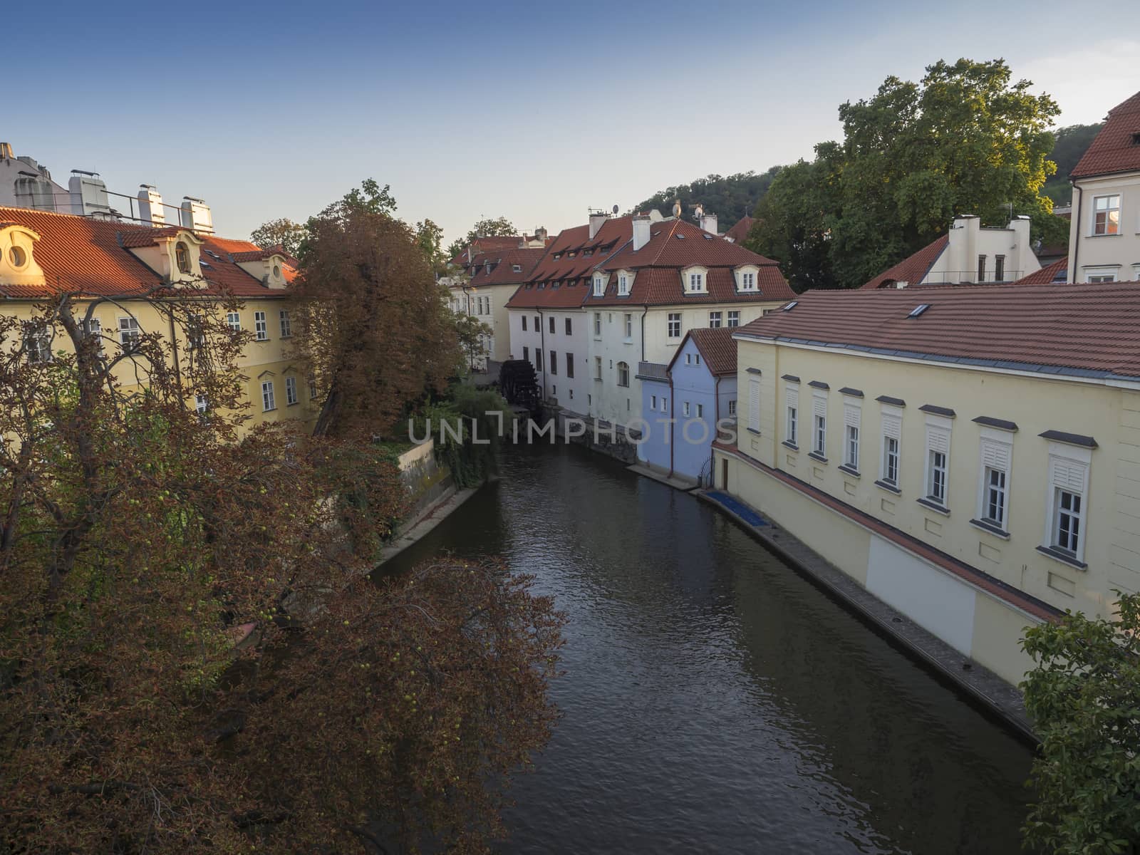 Certovka river, Devil's Channel, also called Little Prague Venice between Kampa island and Mala strana in Czech Republic Prague with Historic wooden Mill Wheel, autumn sunny day.