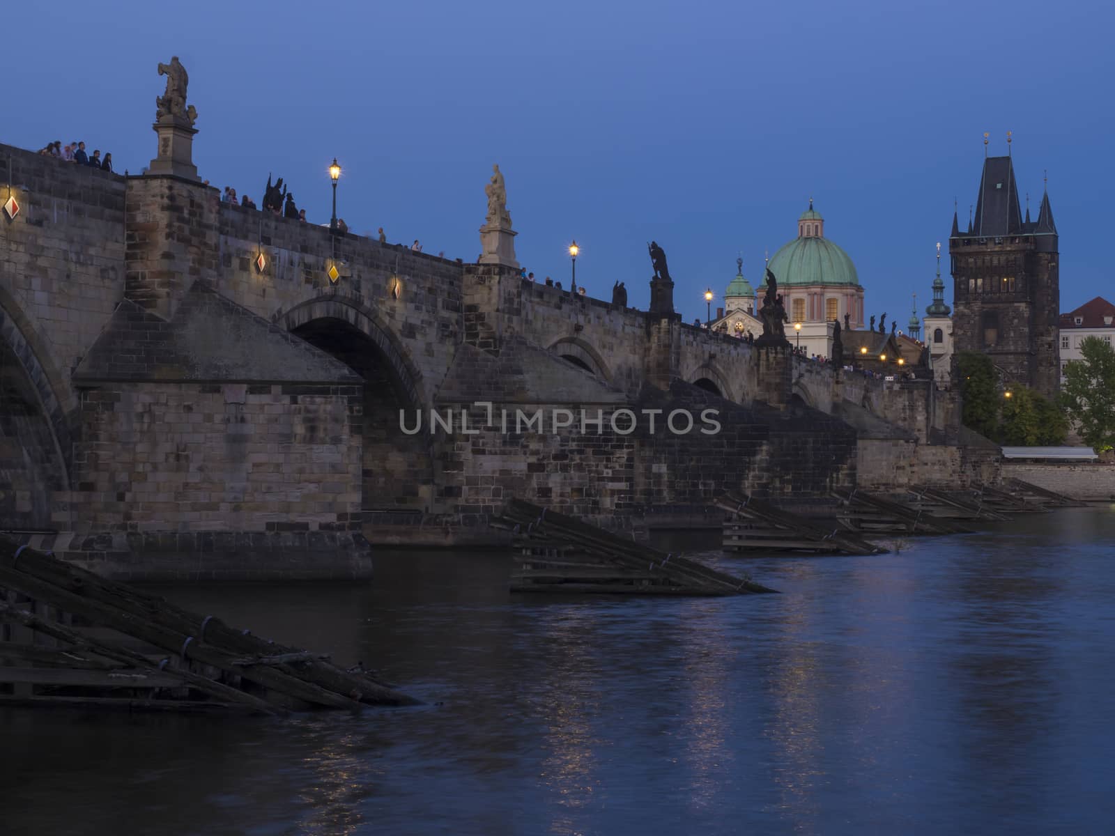 View of iluminated Charles Bridge in Prague from Kampa, Czech Republic. Gothic Charles Bridge is one of the most visited sights in Prague. Architecture and landmark of Prague, night blue hour after sunset.