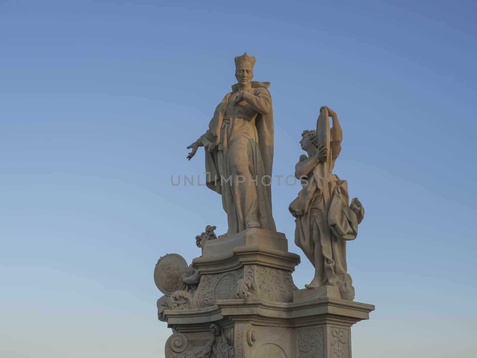 Baroque sand stone Statue Saint on Charles Bridge in Prague, Czech Republic, sunny day, clear blue sky.