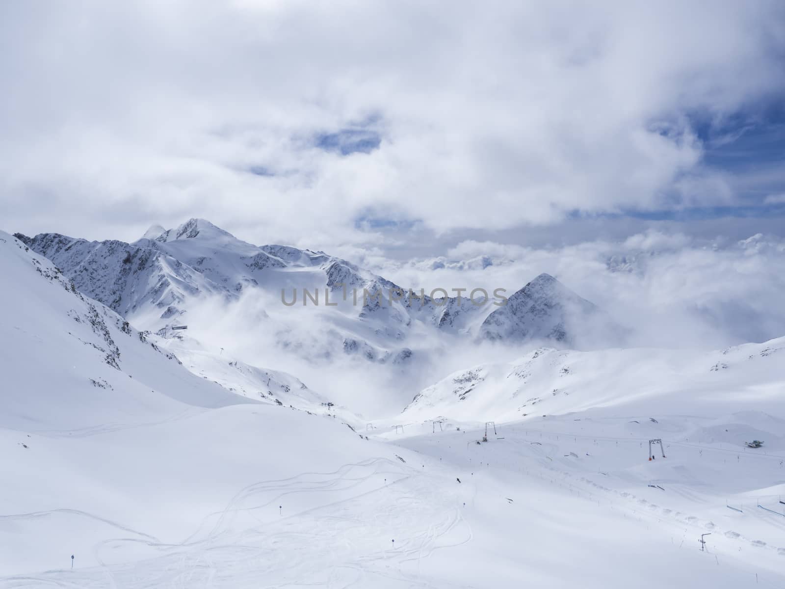 Winter landscape with snow covered mountain slopes and empty pistes, spring sunny day at ski resort Stubai Gletscher, Stubaital, Tyrol, Austrian Alps