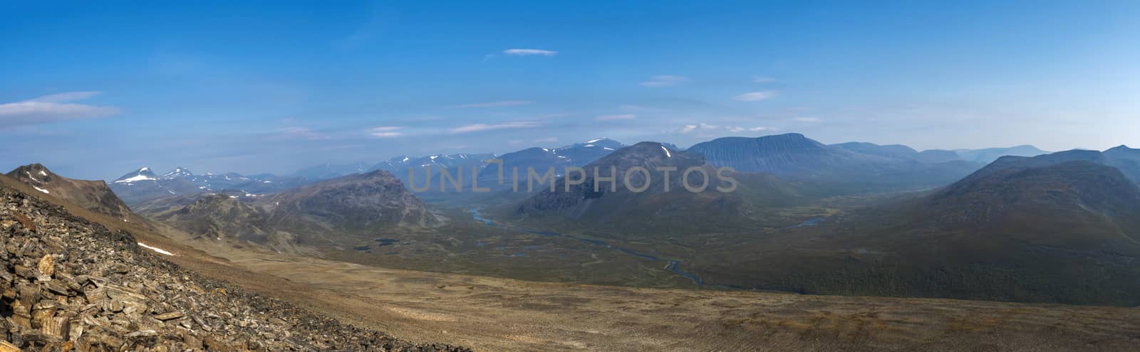 Panoramic aerial view from mountain Sanjartjakka on wild Lapland landscape with Tjaktjajakka river valley, and snow capped mountains. Northern Sweden summer. Blue sky background by Henkeova