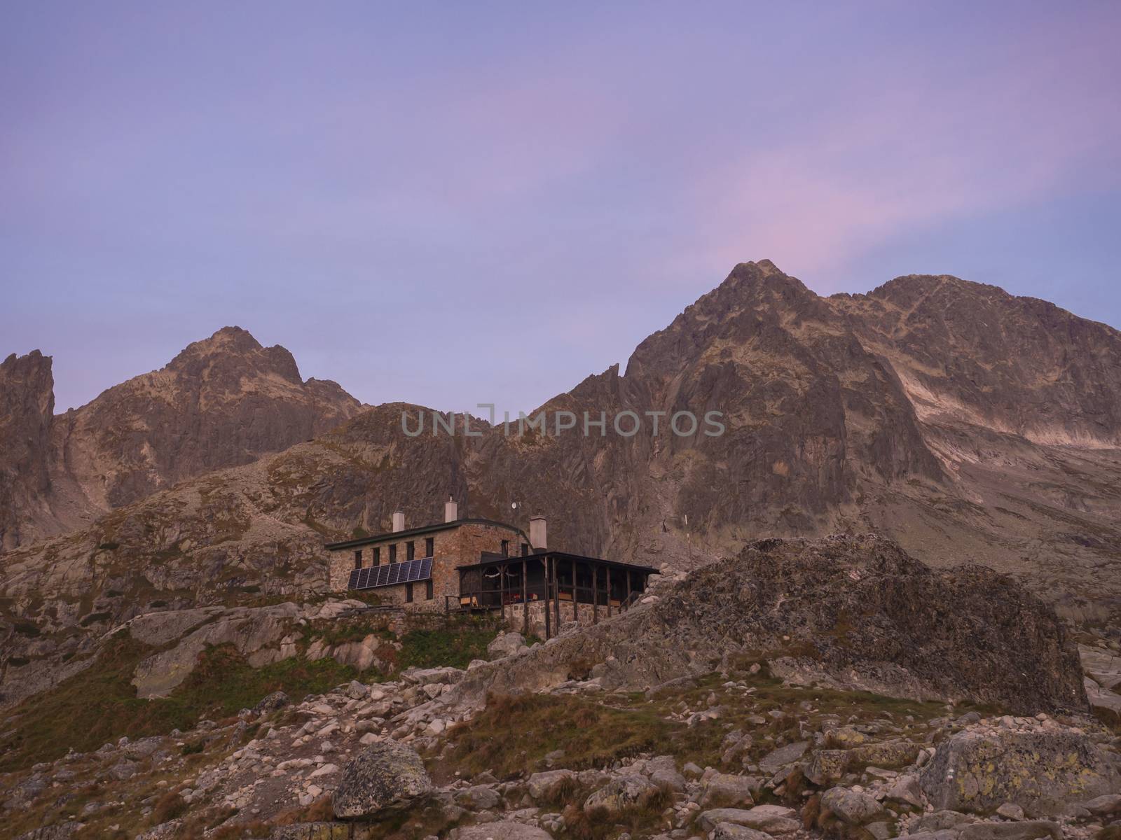 View of the Teryho Chata at sunrise with pink colored mountain peaks and the nature around in the Slovakian mountains High Tatra. This place is very popular by tourists and hikers