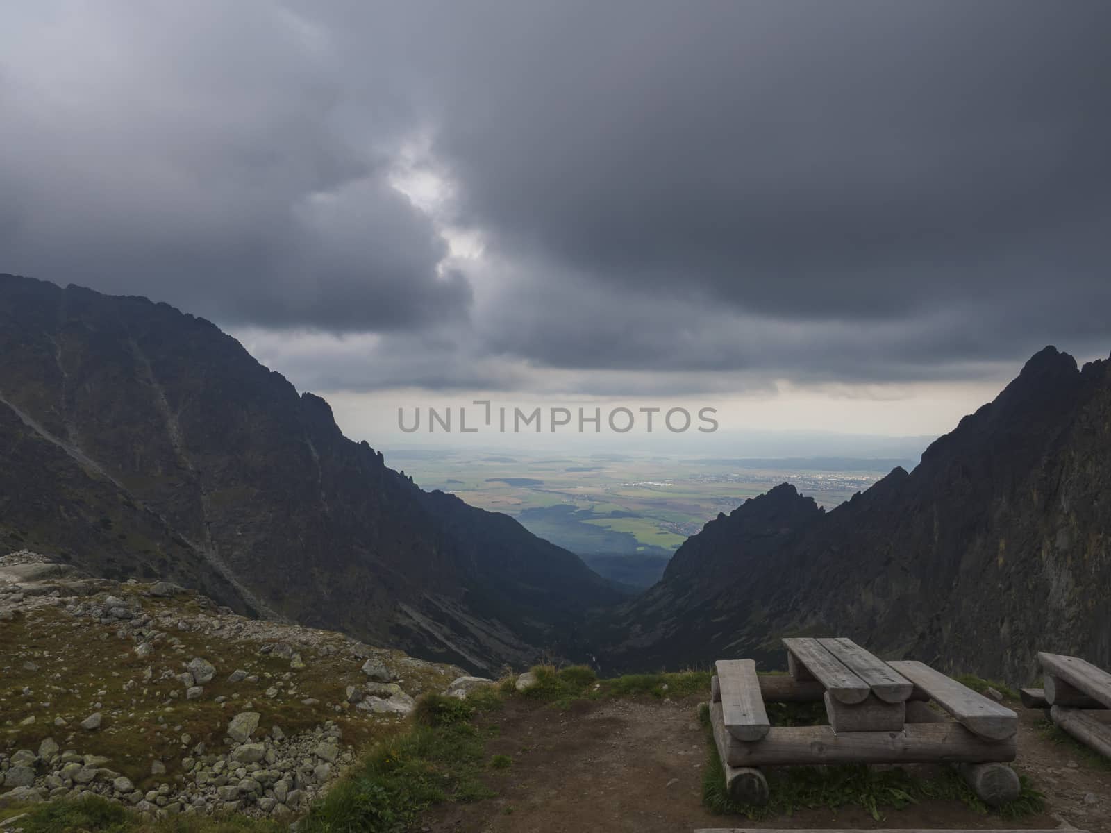 wooden bench and table for eating in the high Tatra mountains in Slovakia with view on valley and foggy sky.