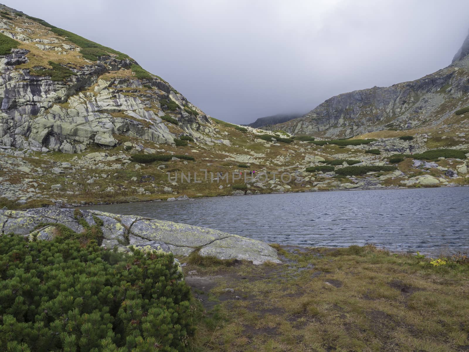 Pleso nad Skokom, beautiful mountain lake in Mlynicka Dolina Valley with hiking peoples on footpath High Tatras mountain, Vysoke Tatry , Slovakia.