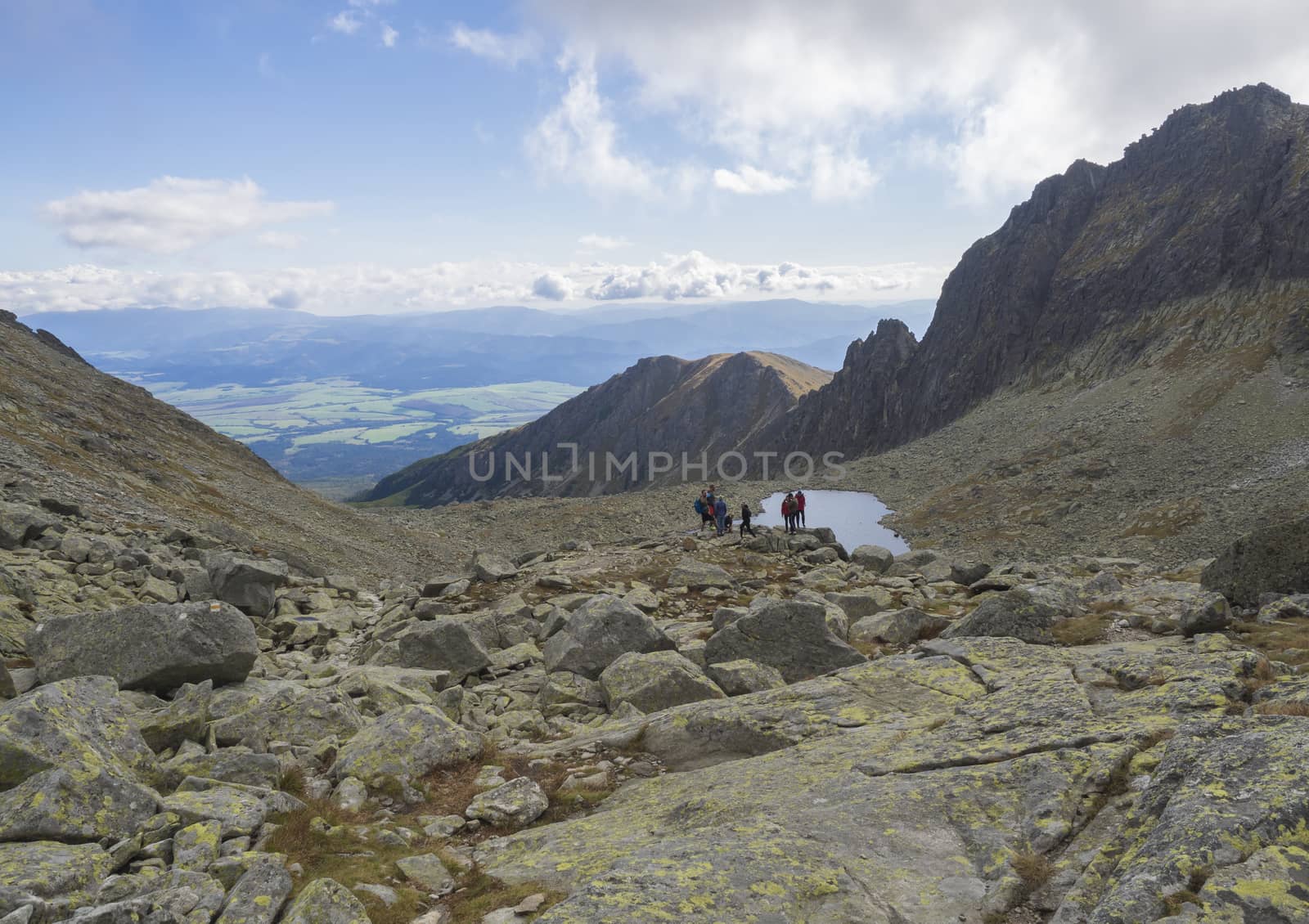 Nizne Wahlenbergovo pleso mountain lake in Furkotska dolina valley with group of resting hikers view from Bystre sedlo pass in high Tatras mountains in Slovakia.