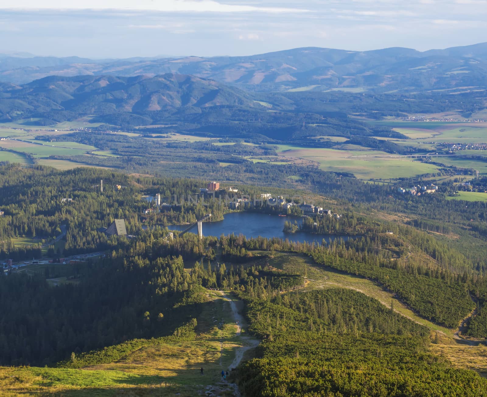 Aerial view on Strbske pleso village and blue mountain lake from chata pod soliskom with forest, hills aHigh Tatra mountains, Slovakia, summer golden hour by Henkeova