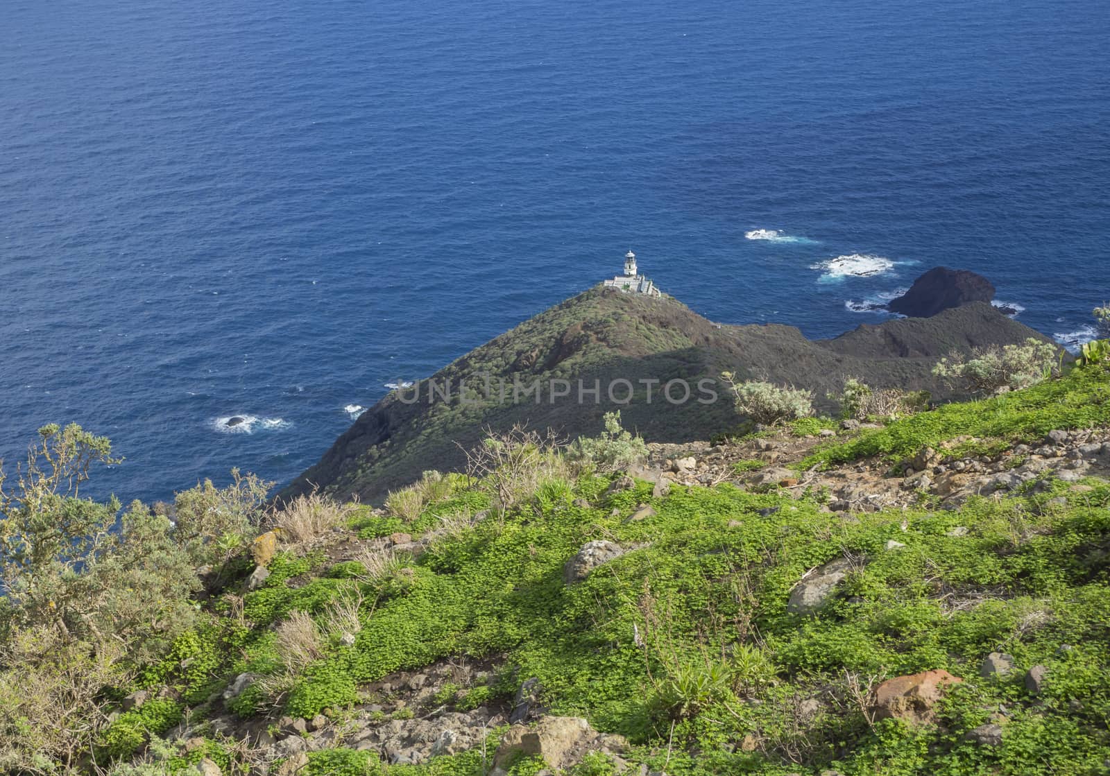 view on Faro de Anaga lighthouse with green hills  blue sea atlantic ocean scenery in anaga mountain, tenerife  canary island spain