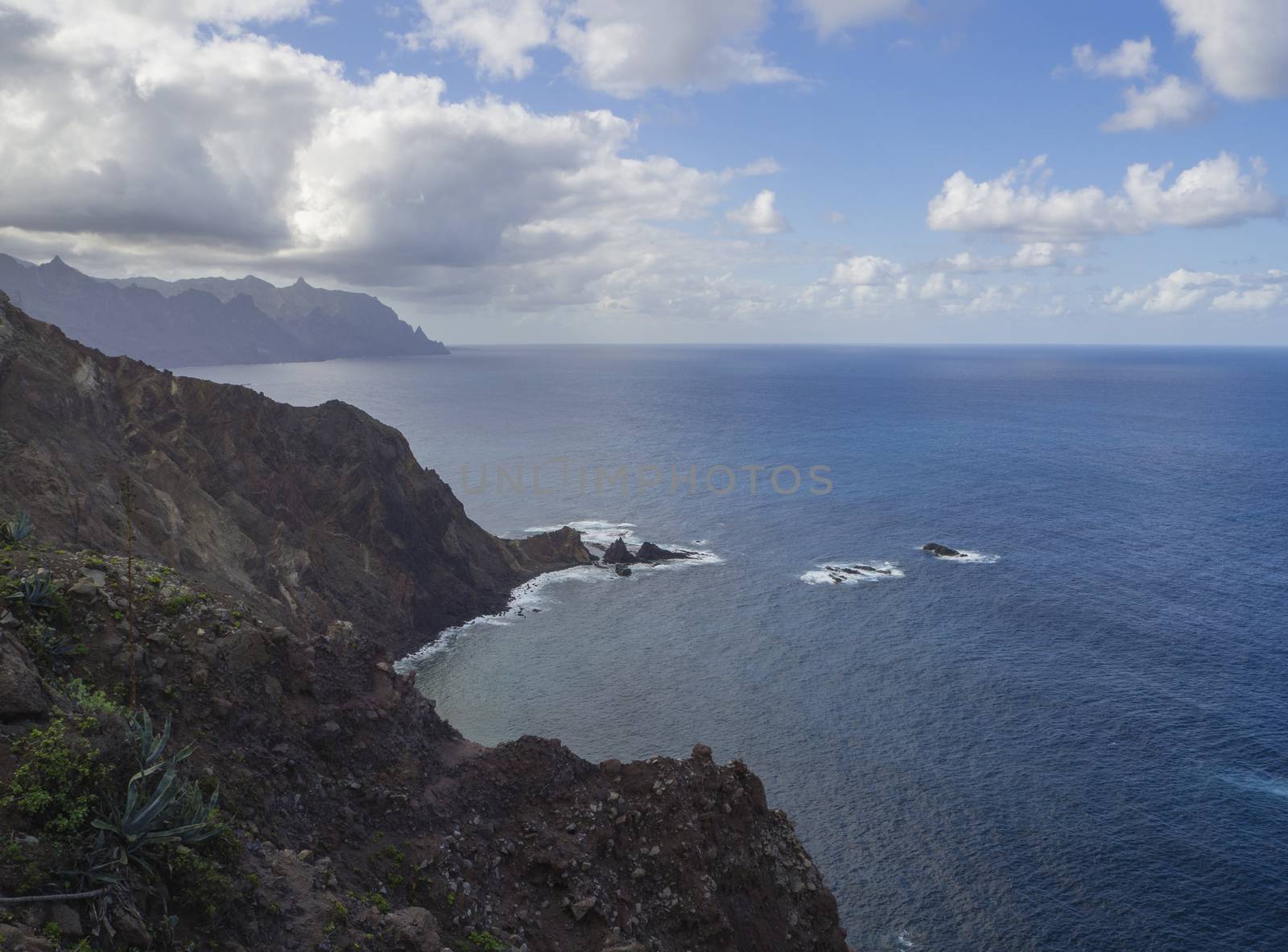 view on high hills and rocky cliffs in the atlantic ocean, sea dramatic blue sky with white clouds in anaga mountain, tenerife  canary island spain