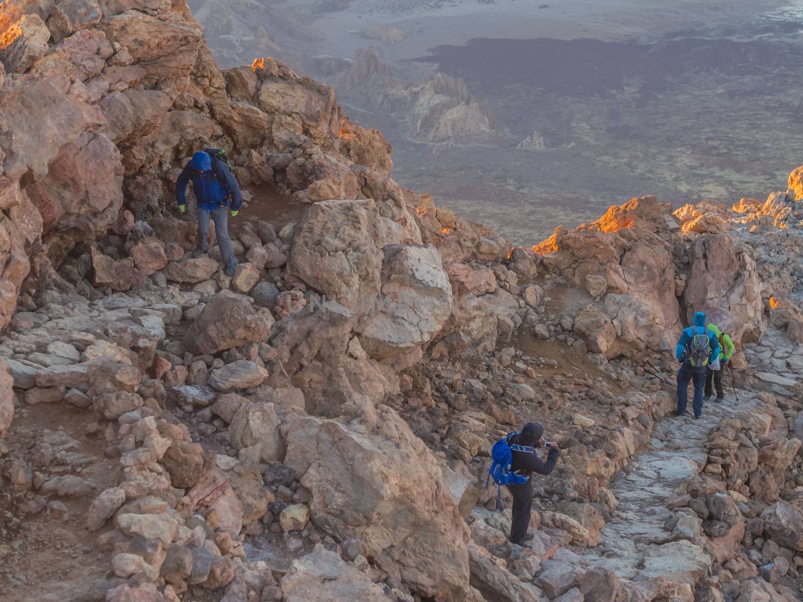 group of tourist hikers walking from sun rise on steep footpath the peak of pico del teide vulcano highest spanish mountain on tenerife canary island