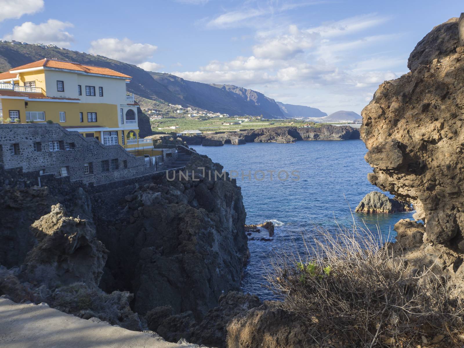 View on bay in San Marcos village with sharp rock and cliffs and villa on Tenerife, sea and blue sky background