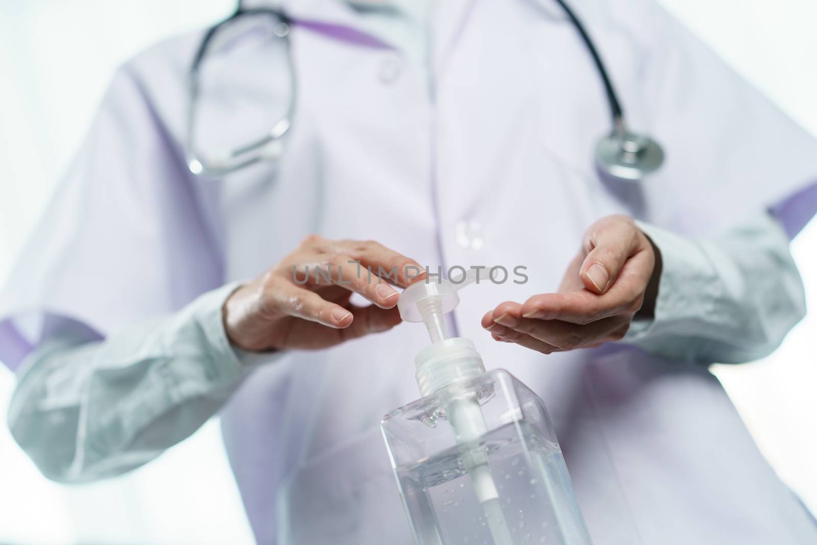 Doctor with white coat using sanitizer alcohol gel for clean hands, corona virus or Covid-19 protection.