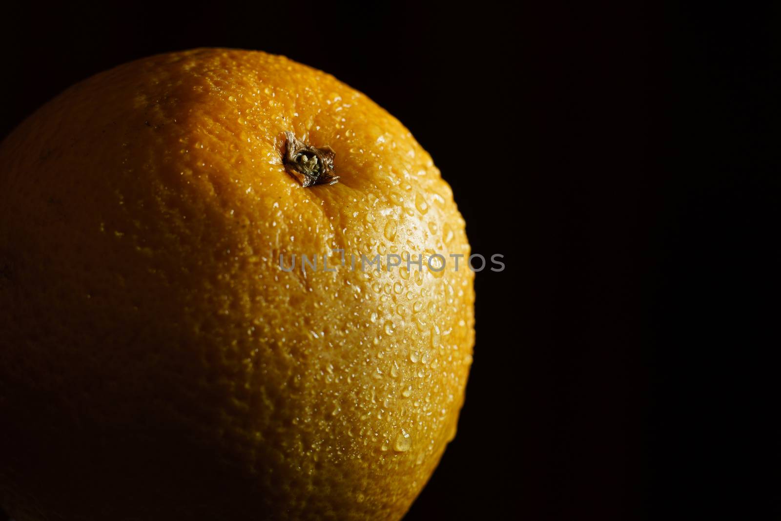 Orange fruit with drops with black background. by sirawit99