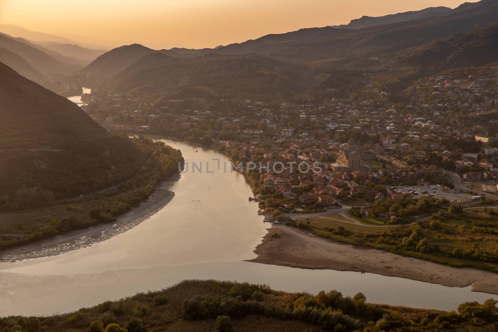 Mtskheta, Georgia, seen from Jvari Monastery showing river confluence and mountains in the background with low sun, very beautiful, golden yellow