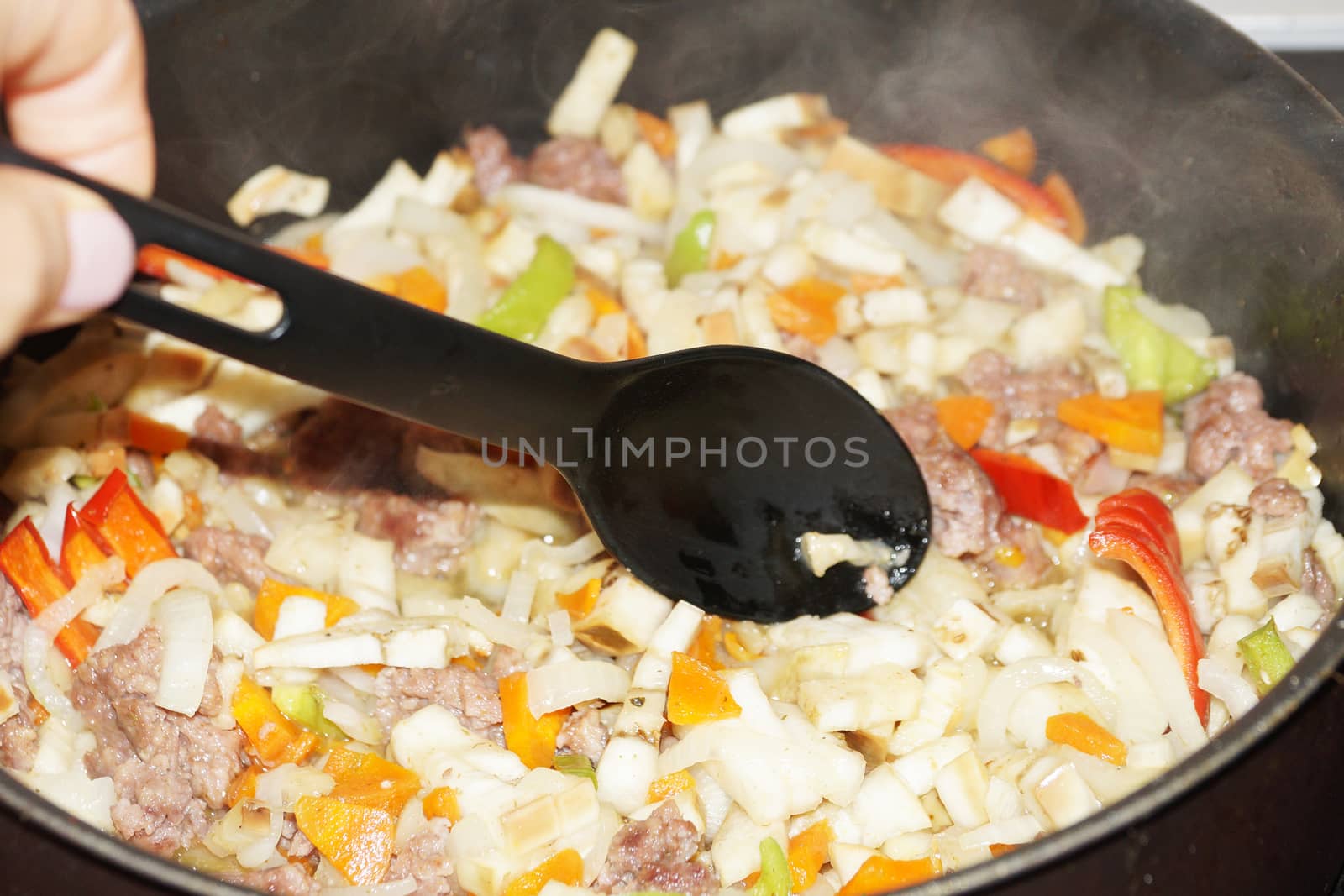 cooking vegetable stew with meat and sour cream in a saucepan by Annado