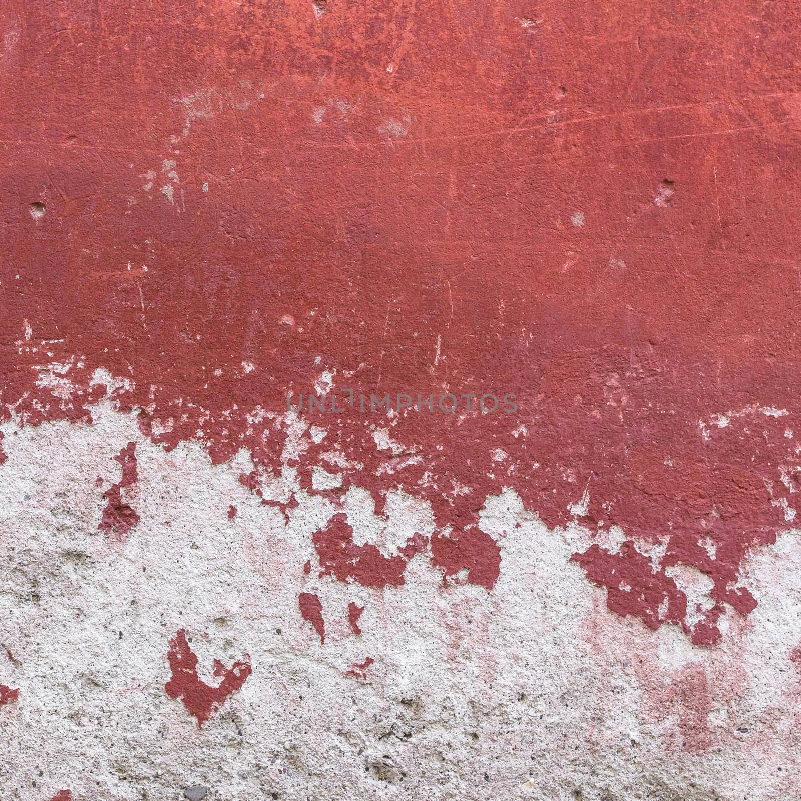 Detail of a wall with red plaster peeling.