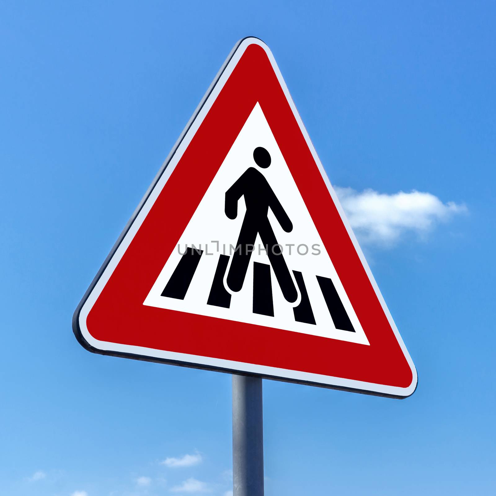 Pedestrian crossing sign against blue sky background