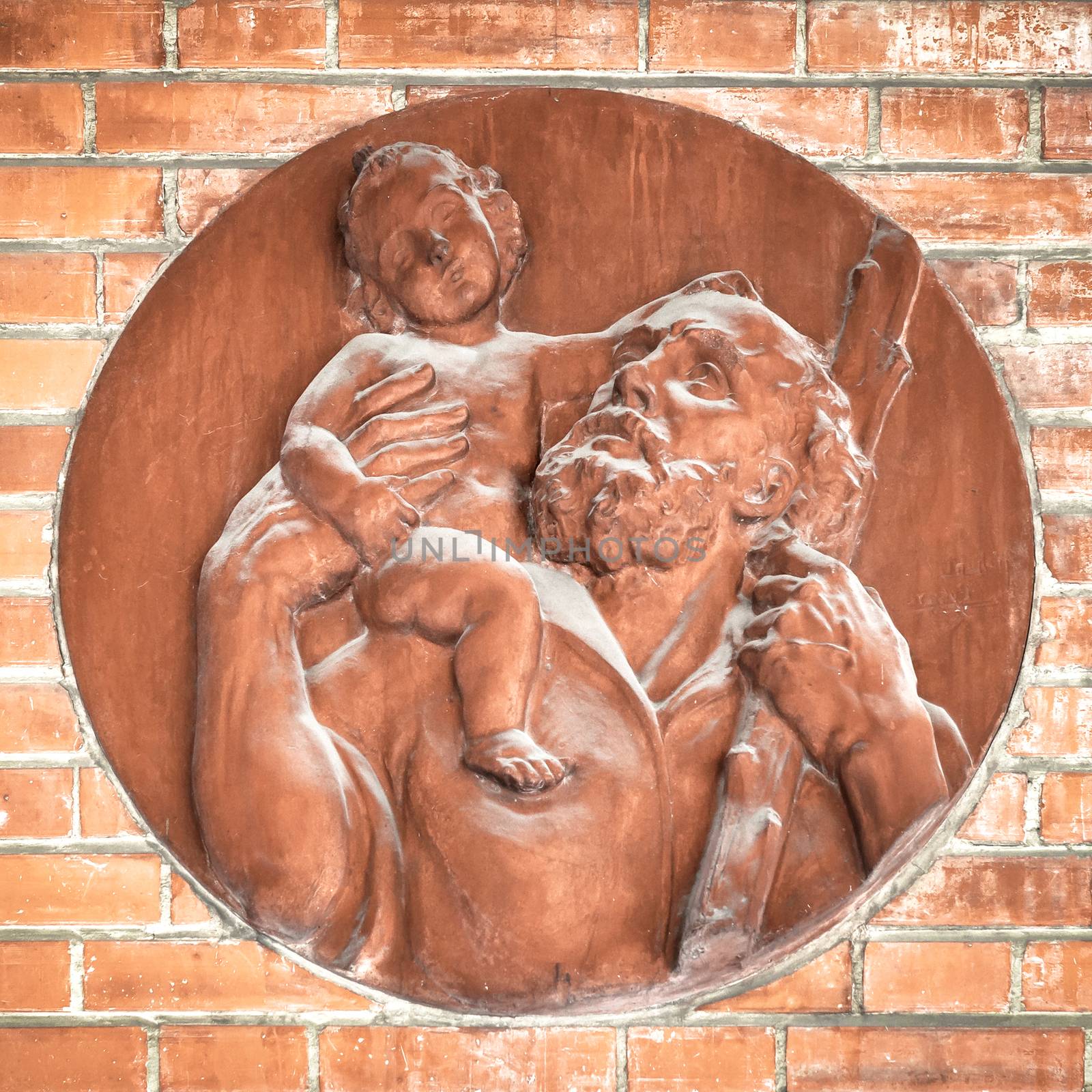 Icon of Jesus and St. Joseph made of terracotta, applied on the exterior wall of a church.