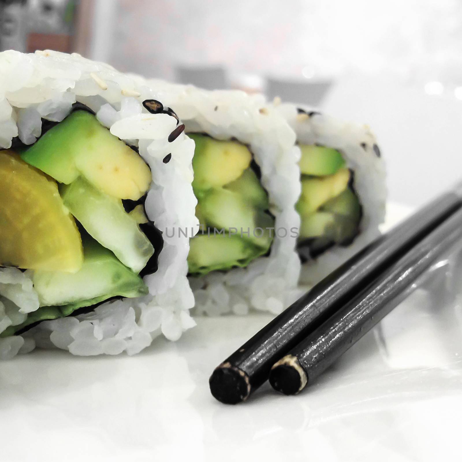 Healthy avocado sushi roll with vintage chopsticks